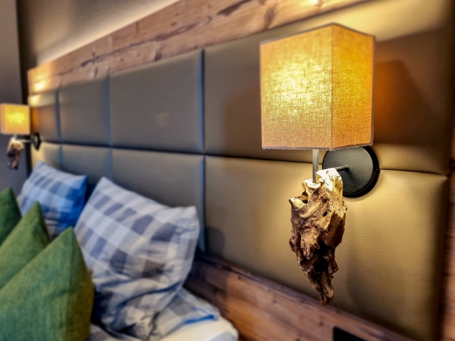 Camera d'albergo moderna in stile floreale – accogliente camera doppia con zona salotto, dettagli in legno e luce serale